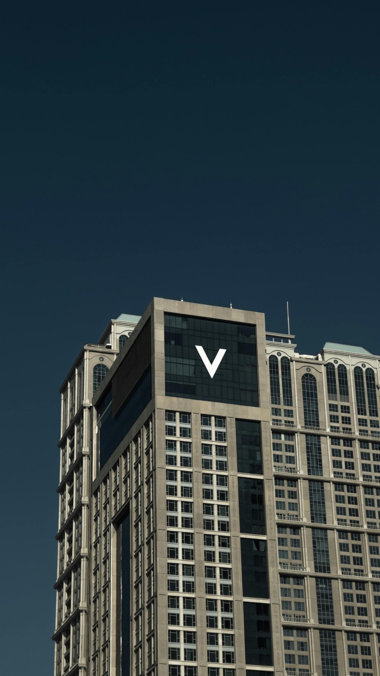 Close-up view of a modern skyscraper facade in Dubai with clear sky background.