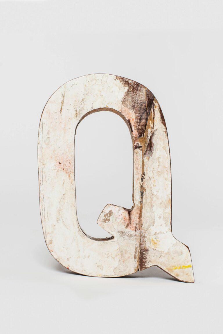A rustic wooden letter Q with a distressed finish, perfect for decor and art projects.